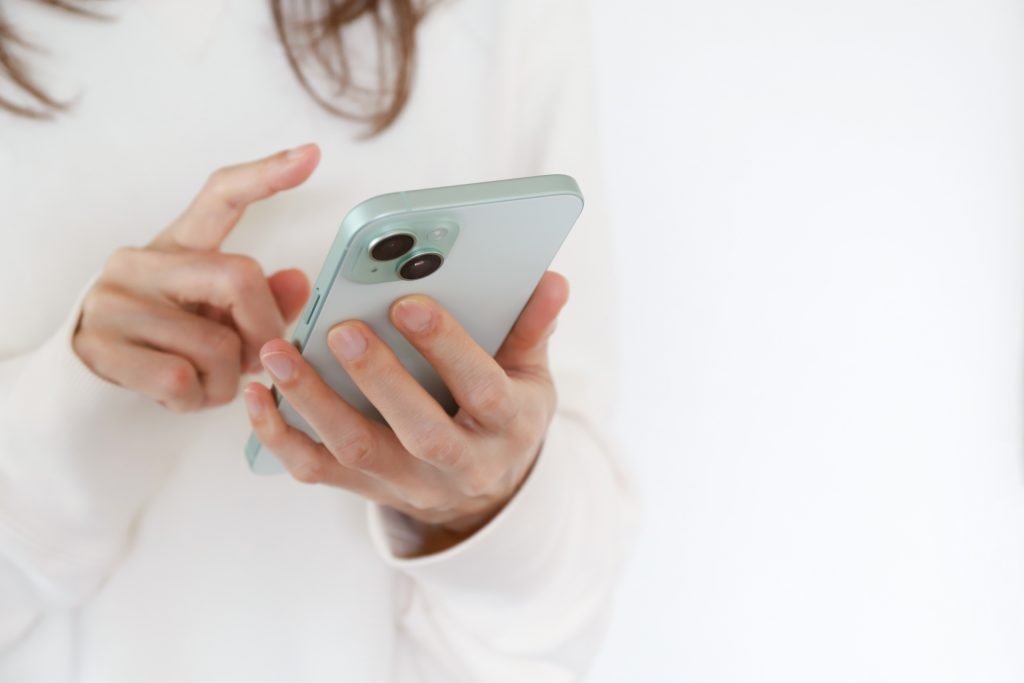 スマートフォンを使う女性の手元