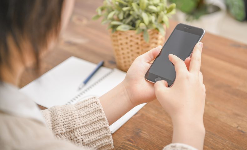 スマホを操作する女性の手元
